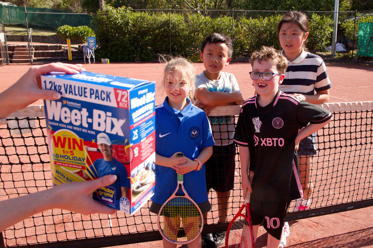 October 16: Sarah, William, Darcy and Luna are surprised to be shown they will be featured on the Weet-Bix box at East Malvern Tennis Club on Thursday, October 16, 2025. Photo by TENNIS AUSTRALIA/HAMISH BLAIR